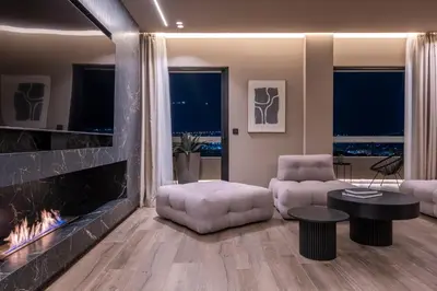 a living room with a fireplace and a couch at The HostMaster Skyline Tower View Suite in Athens