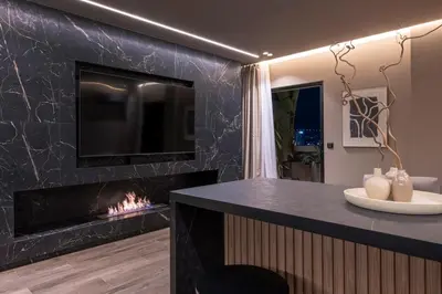 a living room with a fireplace and a tv at The HostMaster Skyline Tower View Suite in Athens