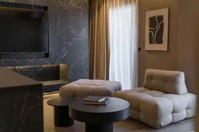 a living room with a couch and a chair and a table at The HostMaster Skyline Tower View Suite in Athens