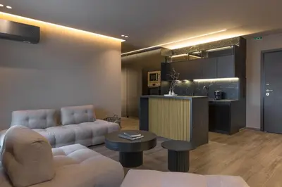 a living room with a couch and a kitchen at The HostMaster Skyline Tower View Suite in Athens