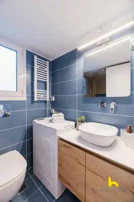 a bathroom with a toilet and a sink and a mirror at Modern Studio Escape near Seaside & Marina! in Athens