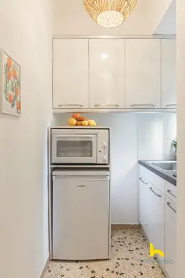 a kitchen with white cabinets and a dishwasher at Modern Studio Escape near Seaside & Marina! in Athens