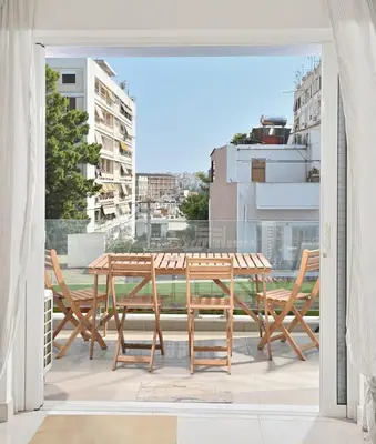 a patio with a table and chairs on a balcony at Lux Lux & modern Apt 5 min Piraeus port - Free Parking in Piraeus