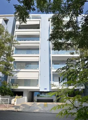 a white apartment building with trees in front of it at Lux Lux & modern Apt 5 min Piraeus port - Free Parking in Piraeus