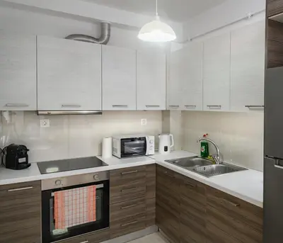 a kitchen with white cabinets and a sink and a microwave at Lux Lux & modern Apt 5 min Piraeus port - Free Parking in Piraeus