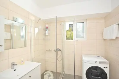 a bathroom with a shower and a washing machine at Lux Lux & modern Apt 5 min Piraeus port - Free Parking in Piraeus