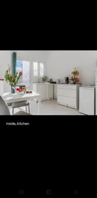 a kitchen with white cabinets and a table and a white table at Dreaming of Greece a4 in Athens