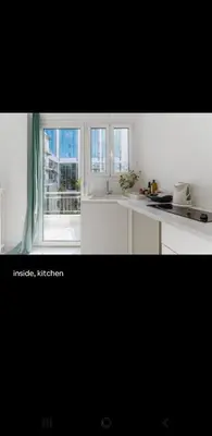 a kitchen with white cabinets and a large window at Dreaming of Greece a4 in Athens