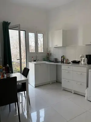 a kitchen with white cabinets and a table and a table and a tableablish at Dreaming of Greece a4 in Athens
