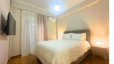 a bedroom with a white bed and a window at Kiafas 5 Apartment Athens in Athens