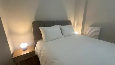 a bedroom with a bed with two lights on it at Kiafas 5 Apartment Athens in Athens