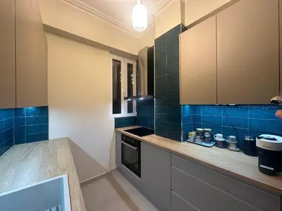 a kitchen with blue tiles on the walls and counters at Kiafas 5 Apartment Athens in Athens