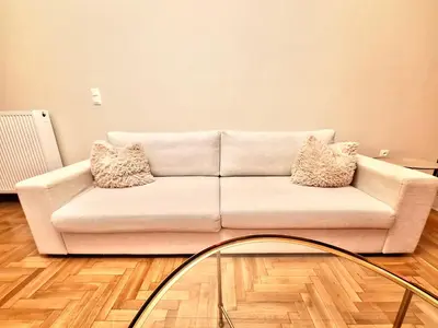 a white couch in a living room with a glass table at Kiafas 5 Apartment Athens in Athens