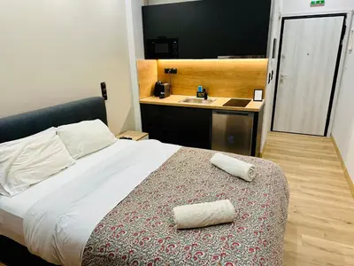 a bedroom with a bed with two towels on it at Brown balcony suite no 2 Piraeus Port in Piraeus