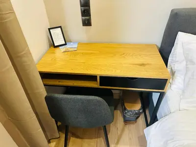 a wooden desk with two chairs next to a bed at Brown balcony suite no 2 Piraeus Port in Piraeus