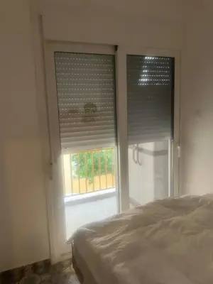a bedroom with a bed and a window with blinds at Sweet Home Athens in Athens