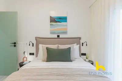 a bedroom with a large bed with a green pillow at Peacefull Family APT W Sunny Balcony in Kallithea in Athens