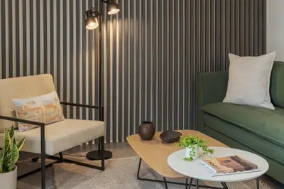a living room with a chair and a coffee table at Peacefull Family APT W Sunny Balcony in Kallithea in Athens