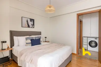 a bedroom with a large white bed with blue pillows at Sky-High Athenian Elegance Retreat With Views! in Athens