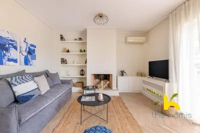a living room with a gray couch and a tv at Sky-High Athenian Elegance Retreat With Views! in Athens