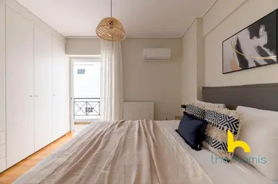 a bedroom with a large bed and a window at Sky-High Athenian Elegance Retreat With Views! in Athens