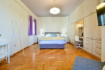 a bedroom with a bed and a desk and a television at Cosy modern flat under the Acropolis in Athens