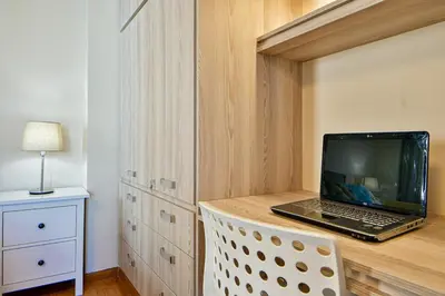 a laptop computer sitting on top of a wooden desk at Cosy modern flat under the Acropolis in Athens