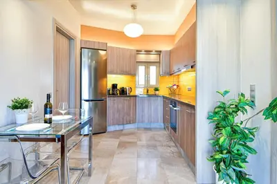 a kitchen with a glass table and a stainless steel refrigerator at Cosy modern flat under the Acropolis in Athens