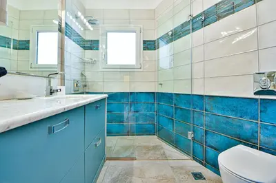 a blue and white bathroom with a toilet and a sink at Cosy modern flat under the Acropolis in Athens
