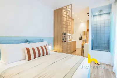 a bedroom with a bed and a room with a door at Stylish Love Nest W Balcony in Heart of Koukaki! in Athens