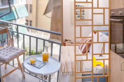 a balcony with a table and a glass of orange juice at Stylish Love Nest W Balcony in Heart of Koukaki! in Athens