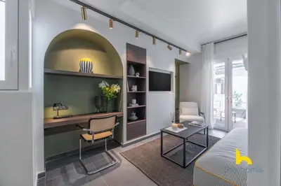 a living room with a couch and a tv at Top-Floor Oasis, King-Bed & Whirlpool, Acropolis! in Athens