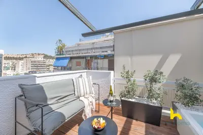a balcony with a couch and a table at Top-Floor Oasis, King-Bed & Whirlpool, Acropolis! in Athens