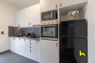 a kitchen with a black refrigerator and a microwave at Top-Floor Oasis, King-Bed & Whirlpool, Acropolis! in Athens