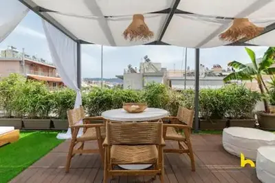 a patio with a table and chairs under an umbrella at Rooftop Hideaway w Large Private Patio near Metro in Athens