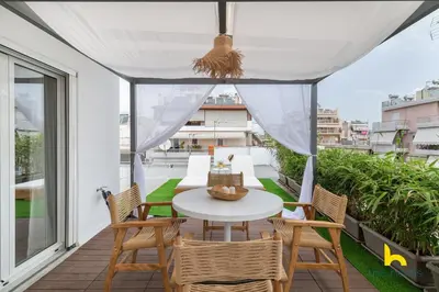 a patio with a table and chairs on a balcony at Rooftop Hideaway w Large Private Patio near Metro in Athens