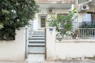 a white house with stairs leading to a door at Ella's Athenian Home in Athens