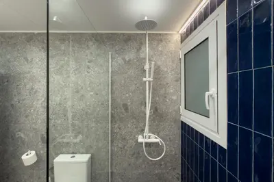a bathroom with a glass shower with a toilet at Ella's Athenian Home in Athens