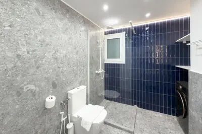 a bathroom with a toilet and blue tiles at Ella's Athenian Home in Athens