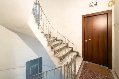 a staircase in a house with a wooden door at Ella's Athenian Home in Athens
