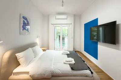 a living room with a bed and a tv at Ella's Athenian Home in Athens