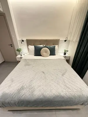 a bedroom with a large bed with blue pillows at Smyrni Cozy Luxury in Athens