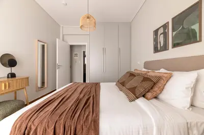 a bedroom with a large bed with white walls at Chalandri Bright 2BR Apartment by UPSTREET in Athens