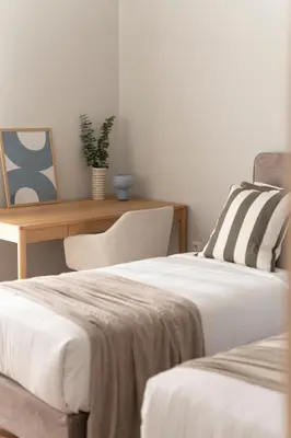 two beds in a room with a table and a chair at Chalandri Bright 2BR Apartment by UPSTREET in Athens