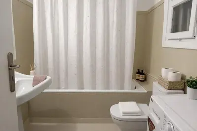 a bathroom with a toilet and a shower curtain at Boutique 5BDT-3 ΒATH Apt with Eclectic Style- Acropolis in Athens