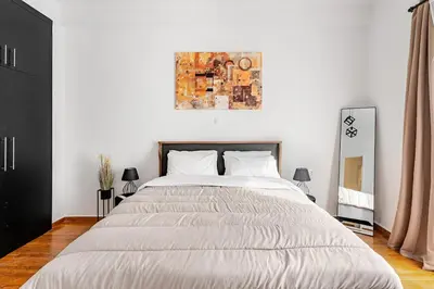 a bedroom with a large bed and a painting on the wall at Boutique 5BDT-3 ΒATH Apt with Eclectic Style- Acropolis in Athens