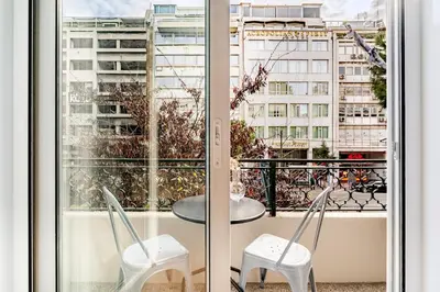 a balcony with a table and chairs and a view of a city at Boutique 5BDT-3 ΒATH Apt with Eclectic Style- Acropolis in Athens