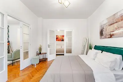 a white bedroom with a large bed with a green headboard at Boutique 5BDT-3 ΒATH Apt with Eclectic Style- Acropolis in Athens