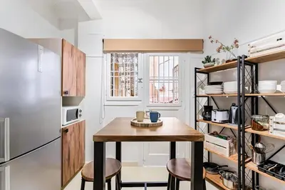 a small kitchen with a table and two stools at Boutique 5BDT-3 ΒATH Apt with Eclectic Style- Acropolis in Athens