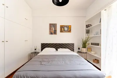 a bedroom with a large bed and white walls at Amazing Luxurious BrandNew 4BDR 2Bath ΑcropolisAPT in Athens
